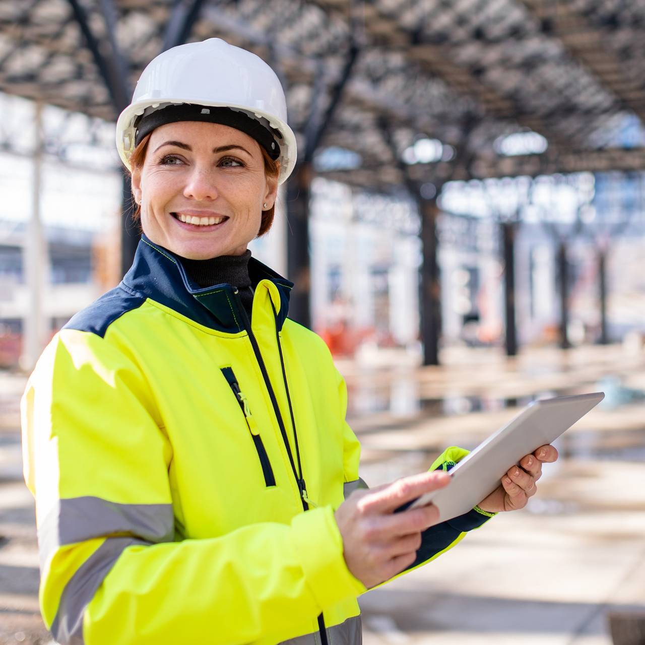 woman engineer with tablet standing on construction site